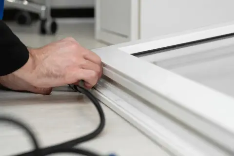 Main tenant en main un outil pour changer joint fenetre pvc.