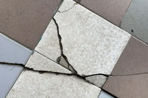 Un carreau de carrelage est brisé, montrant la nécessité de le changer.
