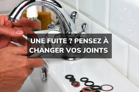 Main d'un bricoleur tenant une clé pour changer un joint de robinet. Des joints neufs sont disposés sur le lavabo.