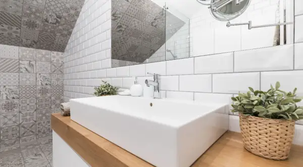 Une salle de bain moderne avec un lavabo rectangulaire blanc, des carreaux muraux blancs et des carreaux décoratifs gris. Une excellente idée carrelage petite salle de bain pour un look chic.