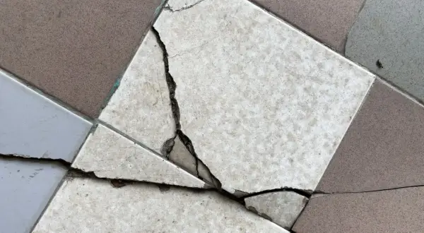 Un carreau de carrelage est brisé, montrant la nécessité de le changer.